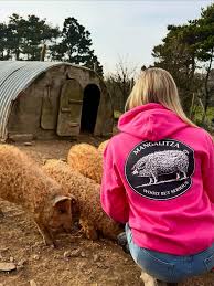 Farm Yard Born ambassador Darcie Burley-Hodge in the pink Mangalitza hoodie with Mangalitsa pigs