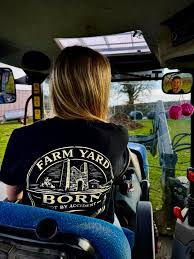 Farm Yard Born ambassador Darcie Burley-Hodge in the black Not By Accident t-shirt, driving a tractor